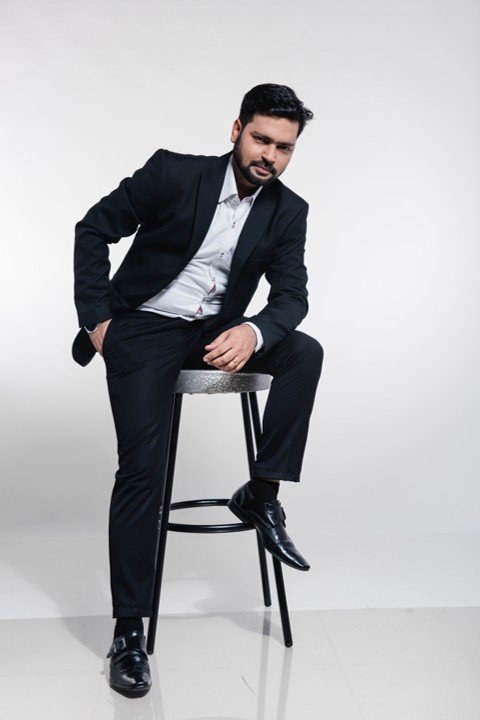 Vineet Sharma seated in a black suit